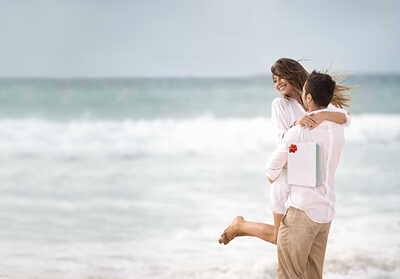 זוג בחופשה בחוף הים עם מתנה